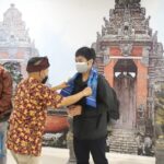 Petugas bandara di Bandara Ngurah Rai Bali memberikan apresiasi dengan cara pengalungan dan bagi souvernir kepada penumpang yang datang terakhir di tahun 2021 dan penumpang yang terbang pertama di tahun 2022