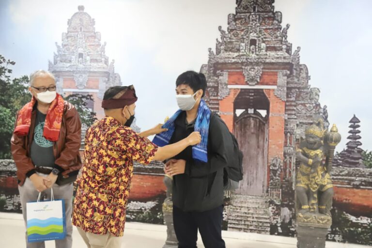 Petugas bandara di Bandara Ngurah Rai Bali memberikan apresiasi dengan cara pengalungan dan bagi souvernir kepada penumpang yang datang terakhir di tahun 2021 dan penumpang yang terbang pertama di tahun 2022