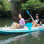 Wisatawan yang sedang melaksanakan tour mangrove dengan cano, sambil melakukan pembersihan