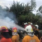 Petugas pemadam kebakaran menyemprotkan air untuk memadamkan kobaran api di sisi selatan Bandara Ngurah Rai, Bali. (Foto: Menitini/M-006)