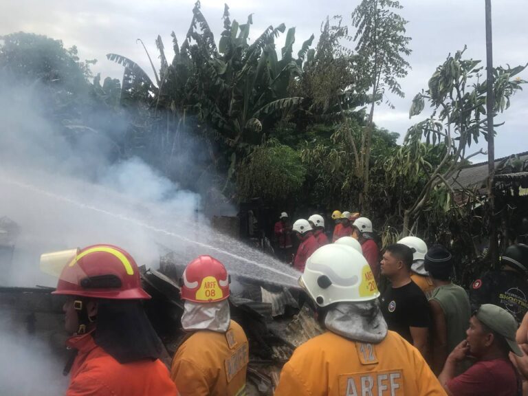 Petugas pemadam kebakaran menyemprotkan air untuk memadamkan kobaran api di sisi selatan Bandara Ngurah Rai, Bali. (Foto: Menitini/M-006)